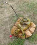 Frog Fishing laying on rocks with fishing pole